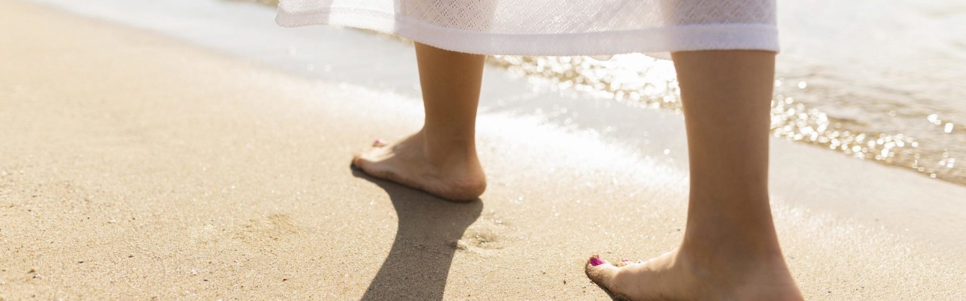 rueckansicht-der-fuesse-der-frau-auf-strandsand